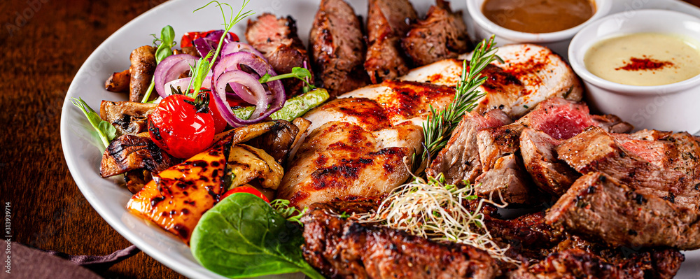 Turkish cuisine. Assorted different meat on the grill, lamb, chicken, pork with grilled vegetables. Serving dishes in a restaurant on a white plate. background image, copy space - obrazy, fototapety, plakaty 
