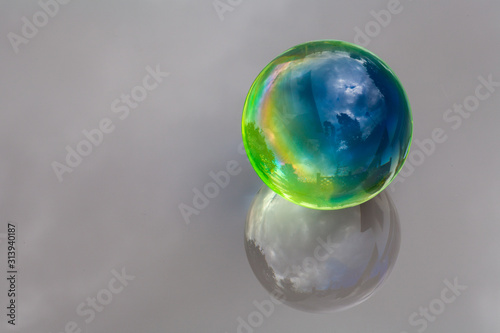 Colored glass ball with mirrors and reflective background