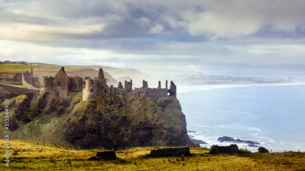 Ruined medieval Dunluce Castle on the cliff dramatic sky. Part of Wild Atlantic Way, Bushmills, County Antrim, Northern Ireland. Filming location of popular TV show, Game of Thrones, Castle Greyjoy