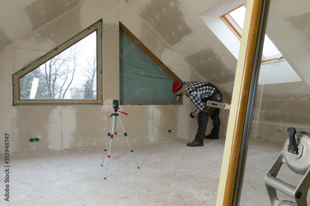 View of Handyman, construction man installing PVC window in a new insulated and ...
