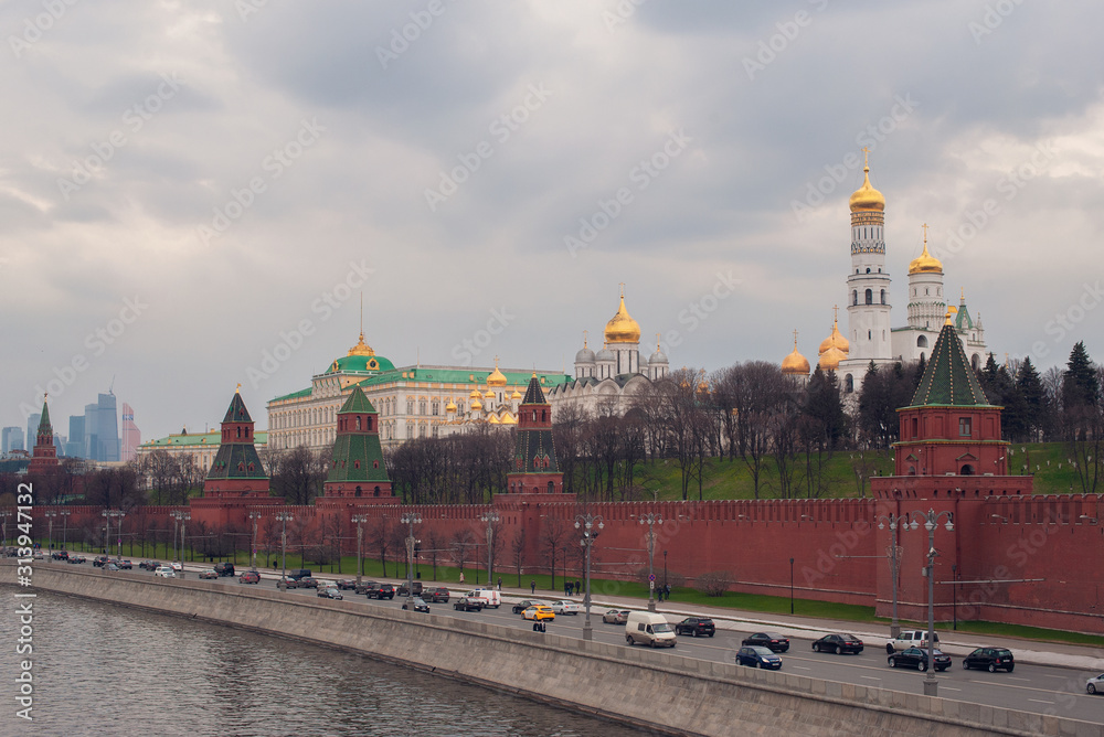 Beautiful view of red brick Moscow kremlin tower with golden church 's domes and the state kremlin palace in winter cloud day.Capital of Russia