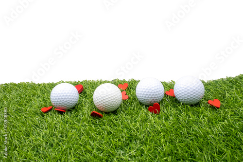 Golf ball and red heart for valentine with love are on green grass