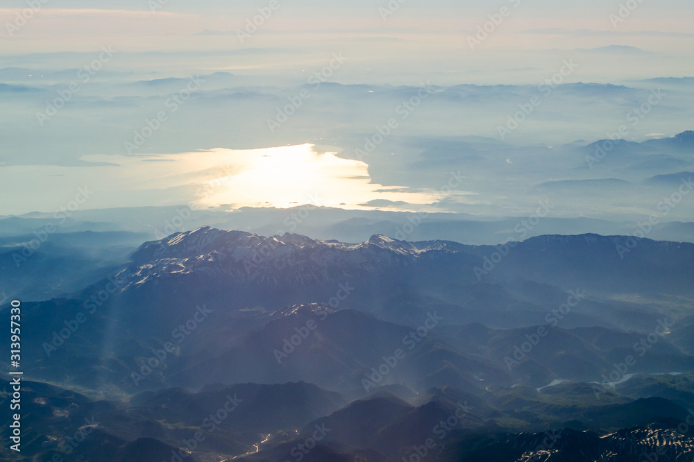 View from the airplane porthole to a mountain landscape View from the airplane porthole to a mountain landscape