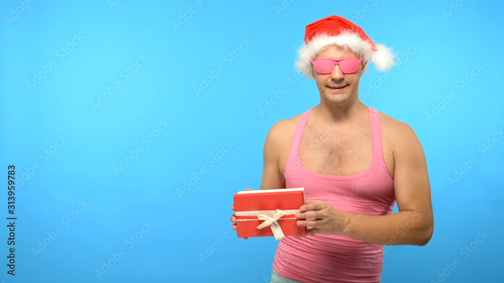 Obraz premium Playful handsome man in a pink T-shirt with fashionable stylish New Year's accessories, in fashionable pink glasses, Merry Christmas and Happy New Year