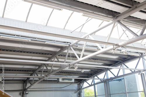 Fragment of roof construction in warehouse. Climate heat panels and lightning