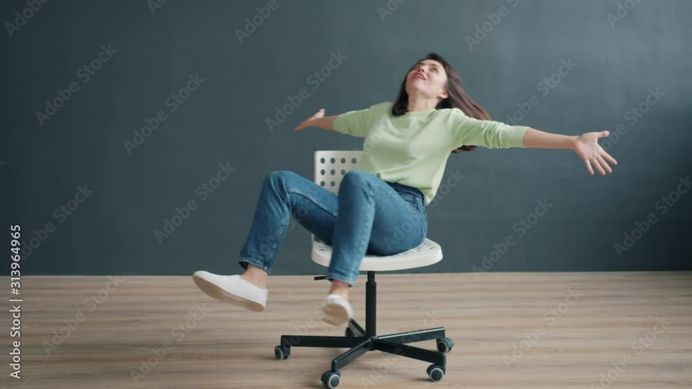 Portrait of carefree lady spinning on chair in studio enjoying funny activity having fun alone on black background. People, entertainment and lifestyle concept. Portrait of carefree lady spinning on chair in studio enjoying funny activity having fun alone on black background. People, entertainment and lifestyle concept.