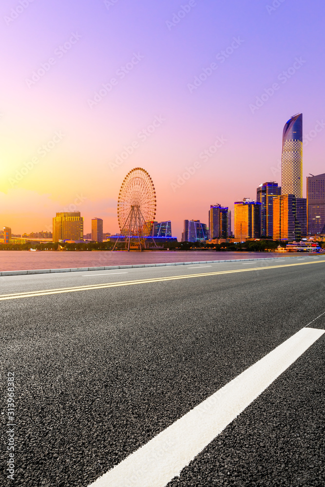 Empty asphalt highway and Suzhou city skyline with beautiful colorful sky at sunset.