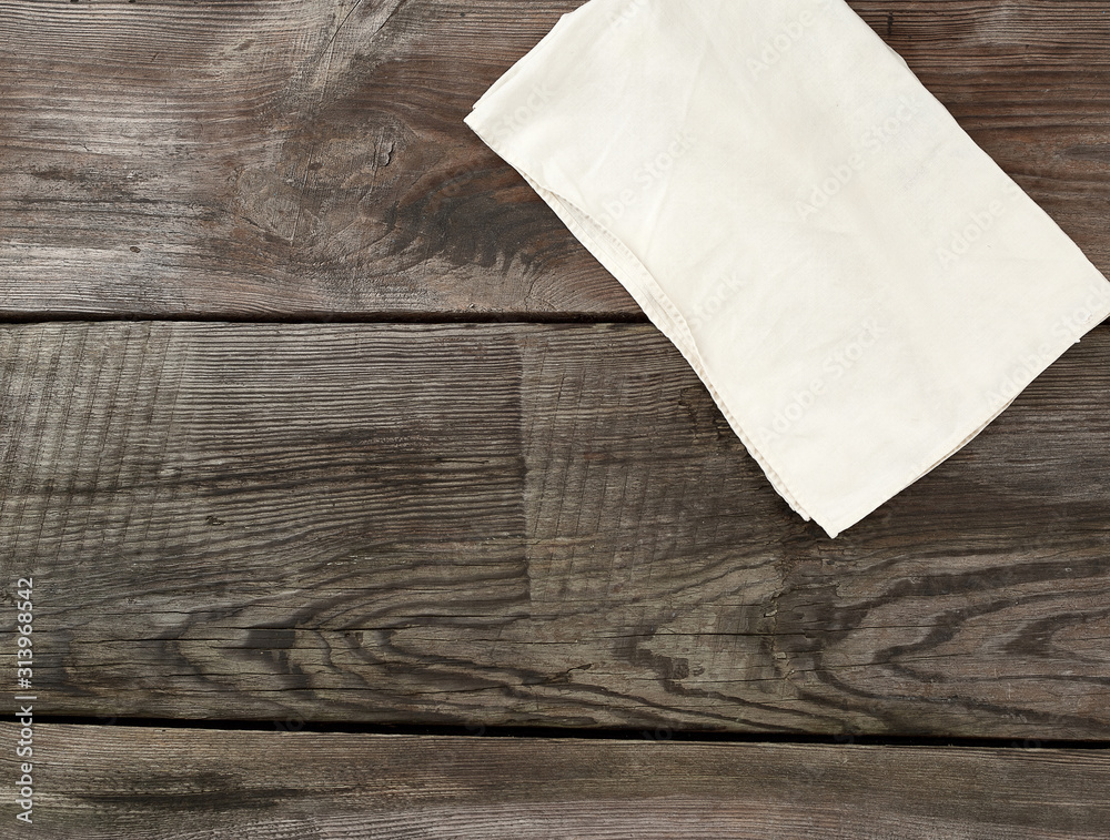white kitchen textile towel folded on a gray wooden table from old boards, top view, empty space white kitchen textile towel folded on a gray wooden table from old boards, top view, empty space
