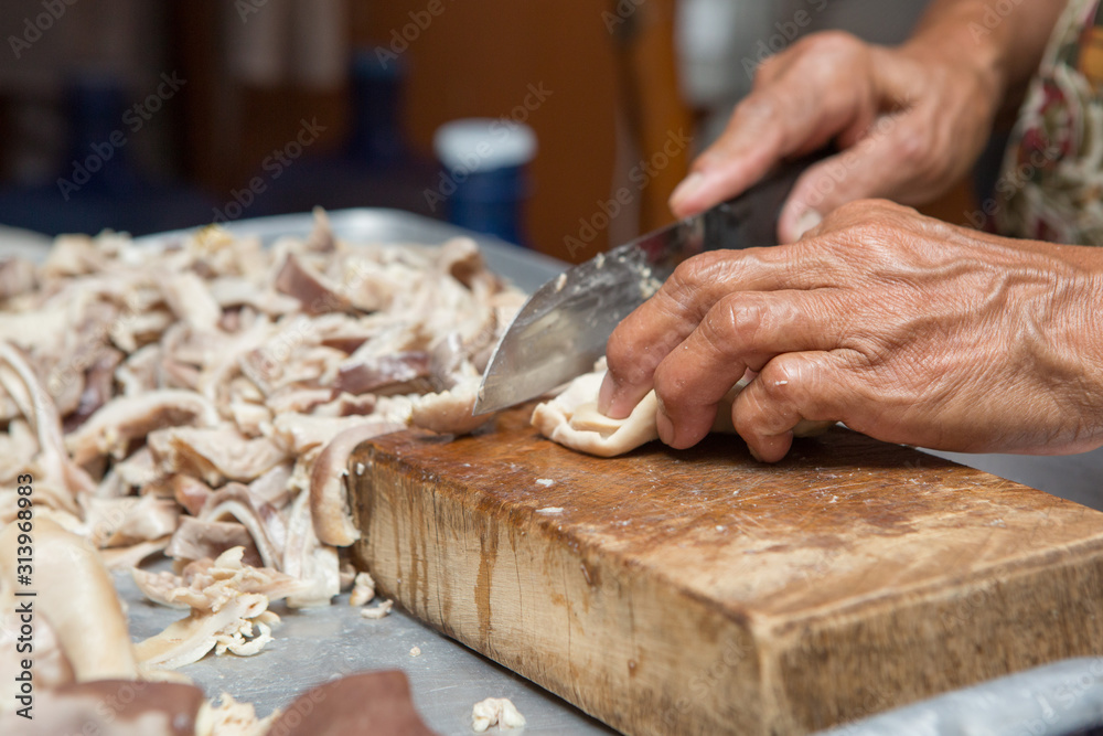 Selective focus of cook is cutting the boiled pork on the cutting board Selective focus of cook is cutting the boiled pork on the cutting board