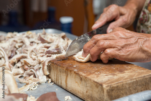 Selective focus of cook is cutting the boiled pork on the cutting board