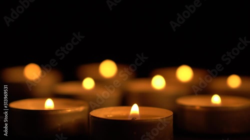 Slow motion white candles light up flames fire on isolated black background. Use in romantic dinner, warm and relax peace maditaion, use for spiritual religion church decotion and Halloween graveyard