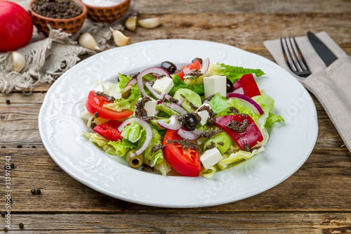 Greek salad with feta on wooden table