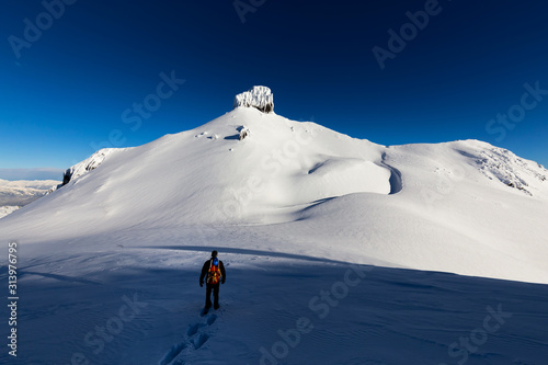 Garibaldi, between Whistler and Squamish, North of Vancouver, British Columbia, Canada. Adventurous man Snowshoeing on the snow in the remote Canadian Mountain Landscape during sunny winter day.