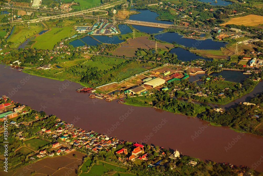 Aerial view of Chao Phraya River. Rural area and agricultural area at sunset. Houses in village and trees in forest in Bangkok City, Thailand