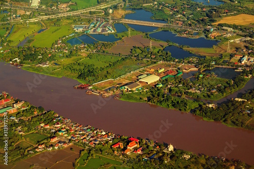 Aerial view of Chao Phraya River. Rural area and agricultural area at sunset. Houses in village and trees in forest in Bangkok City  Thailand