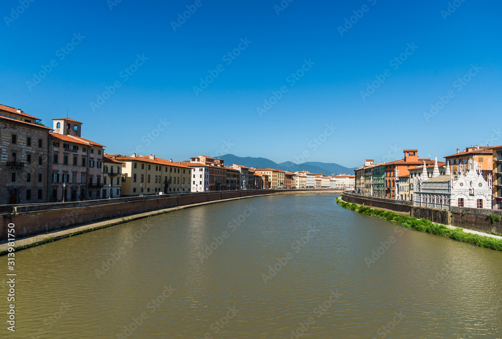 Traditional colorful ancient Italian architecture houses in Pisa, Italy, alongside the embankment of Arno river