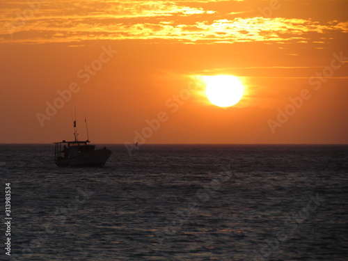 Fishing boat starting work at sunset.