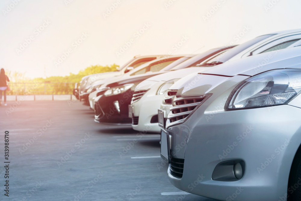 Naklejka premium Car parking in asphalt parking lot in a row, front of cars close up