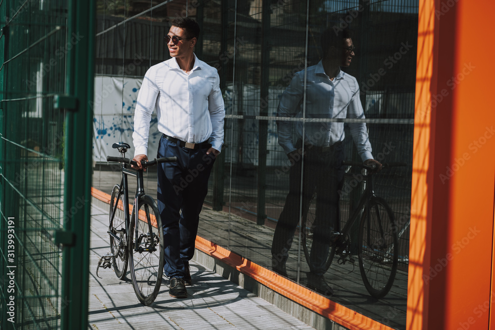Smiling executive using bicycle in city stock photo