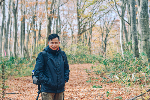 Asian man traveler enjoying autumn forest