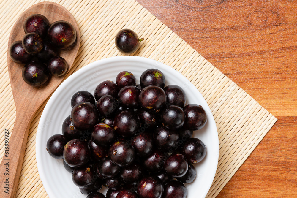 Jabuticaba in the wooden spoon and bowl. Jaboticaba or Jabuticaba is the native Brazilian grape tree. Species Plinia Cauliflora. Brazilian Berry. Jabuticaba in the wooden spoon and bowl. Jaboticaba or Jabuticaba is the native Brazilian grape tree. Species Plinia Cauliflora. Brazilian Berry.