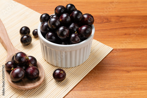Jabuticaba in the wooden spoon and bowl. Jaboticaba or Jabuticaba is the native Brazilian grape tree. Species Plinia Cauliflora. Brazilian Berry.
