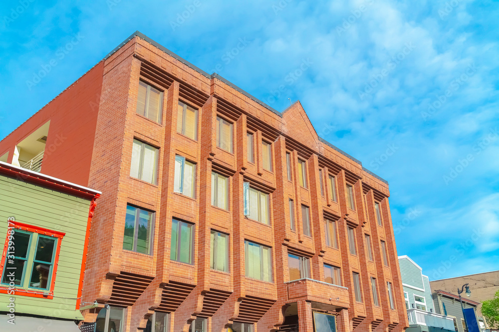Exterior of a multi storey building with red brick walls and tall glass windows
