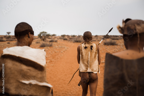 original native bushman from Namibia with traditional clothing from behind photo