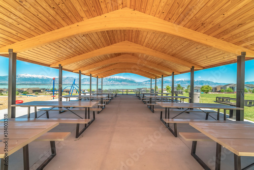 Pavilion with brown wooden ceiling overlooking lake and snow capped mountain © Jason