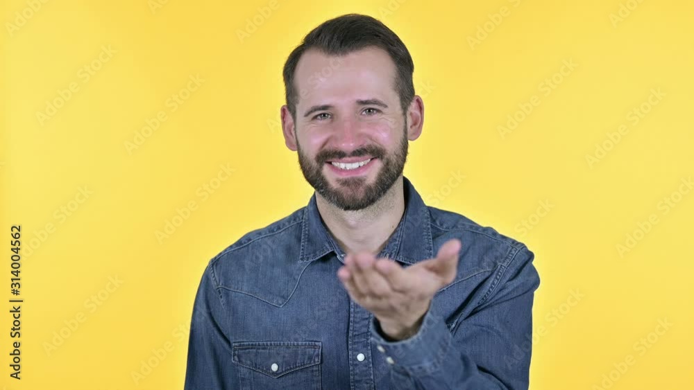 Beard Young Man giving Flying Kiss, Yellow Background
