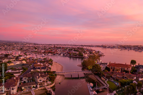 Pink sunset over Newport Beach harbor island's waterfront homes.