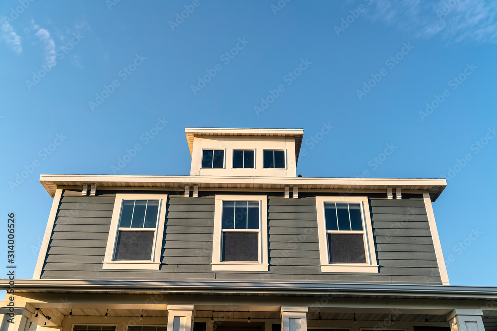 Grey wooden house with three upper windows