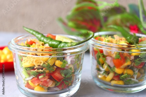 Food vegetable salad with corn and onions, tomatoes, coriander, lemons. healthy green meal. Indian Corn Masala chaat. Recipe ingredients with copy space,