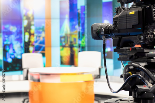 фотографія Camera in studio are broadcasting journalists reading news