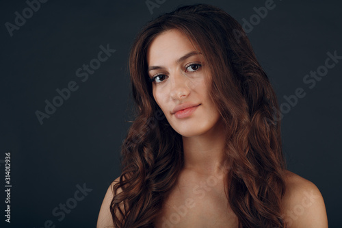 Portrait of beautiful smiling young brunette woman with healthy fluffy hair