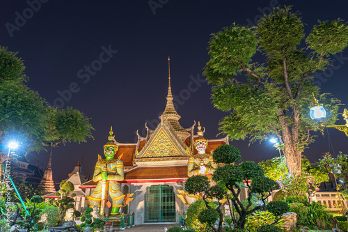 Large illuminated temple Wat Arun after sunset seen accross river Chao Phraya Bangkok, Thailand.golden Buddha in side temple Wat Arun the biggest and tallest pagoda in the world