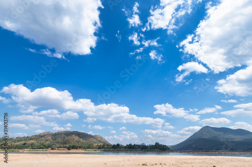 dry sand ground of Mae Khong river with Mountain views on blue sky background texture with white cloud of Laos at the Kaeng Khud Khu rapids at Chiang Khan in Loei province Thailand The River Crisis