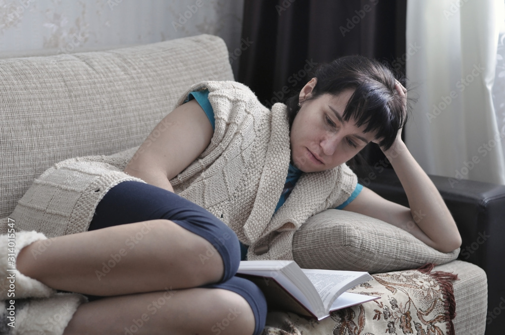Obraz premium beautiful girl at home lying and reading a book.