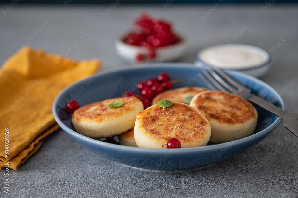 Syrniki or cottage cheese pancakes with fresh red currant. Tasty healthy breakfast.
