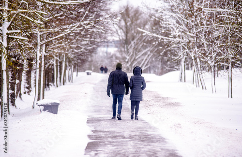 A guy and a girl walking in winter Park