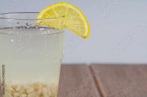 Close up on water sparkle on the glass with lemon attached.