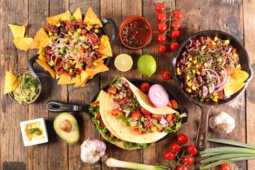 assorted of mexican food with fajitas, chili con carne and nachos with avocado, beef and cheese