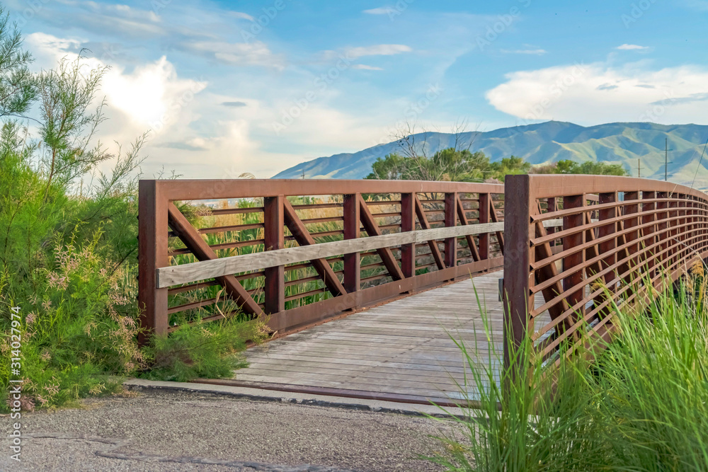 Bridge with scenic view of tall mountain and cloudy pale blue sky landcsape