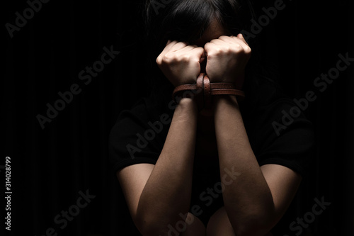 Woman tied up with leather belt in emotional stress and pain photo
