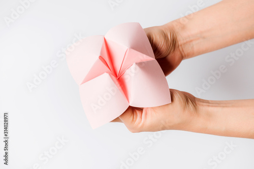 Hand in a paper fortune teller isolated on white background. photo