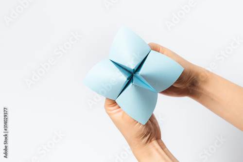Εκτύπωση καμβά Hand in a paper fortune teller isolated on white background.