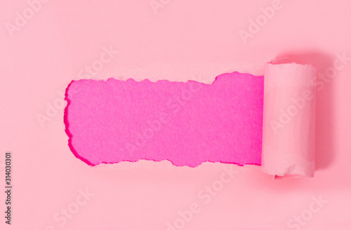 Top view of pink torn paper on pink background.