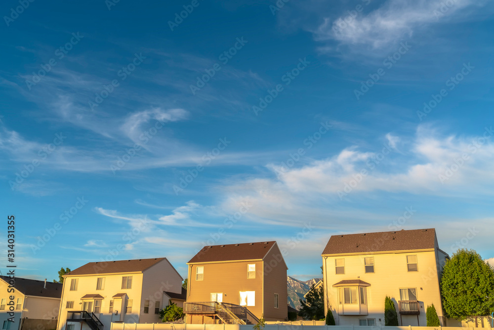 Home exterior with balconies stairs bay windows yards and fences on a sunny day