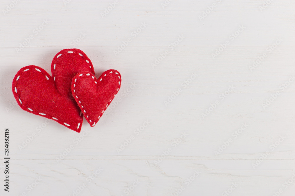 Red hearts are handmade on white background. Preparation for Valentine's Day with a place for text. Copy space. Red hearts are handmade on white background. Preparation for Valentine's Day with a place for text. Copy space.