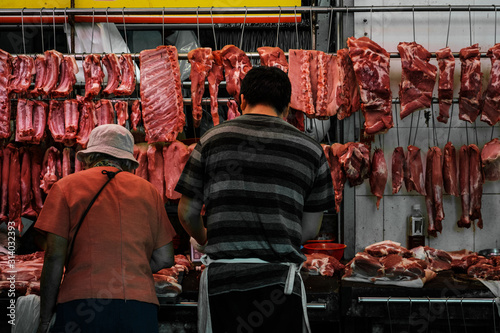 Canvas Print Butcher and customer buying and selling meat on street market store in Hong Kong
